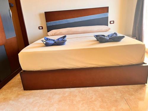 a bed with two blue pillows on it at Reef House in Marsa Alam City