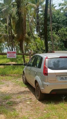 a white car parked on the side of a road at Villa Avni, a beach side family retreat, Homestay in Nīleshwar