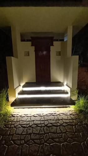 a building with a staircase with lights on it at Villa Avni, a beach side family retreat, Homestay in Nīleshwar
