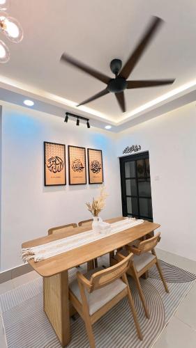 a dining room with a table and a ceiling fan at Inara Homestay in Kuala Lumpur