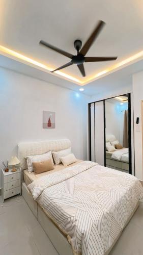 a bedroom with a large bed with a ceiling fan at Inara Homestay in Kuala Lumpur