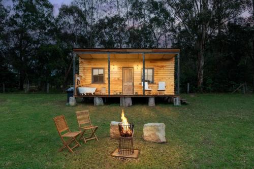 a tiny house with a fire in the yard at 'Casuarina' - Picturesque Kangaroo Valley Cottage in Kangaroo Valley