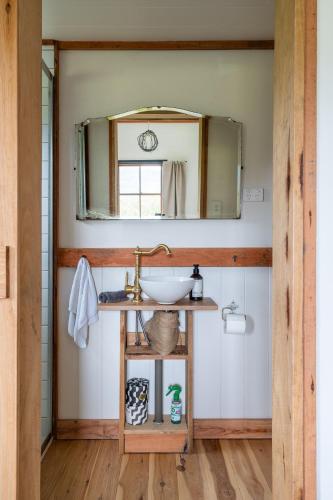 a bathroom with a sink and a mirror at 'Casuarina' - Picturesque Kangaroo Valley Cottage in Kangaroo Valley