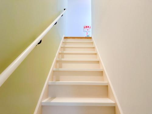 a staircase in a room with white walls at Saboten in Sesoko