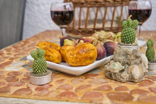 a table with a plate of food and two glasses of wine at Valley View Studio Apartment Salakos in Sálakos