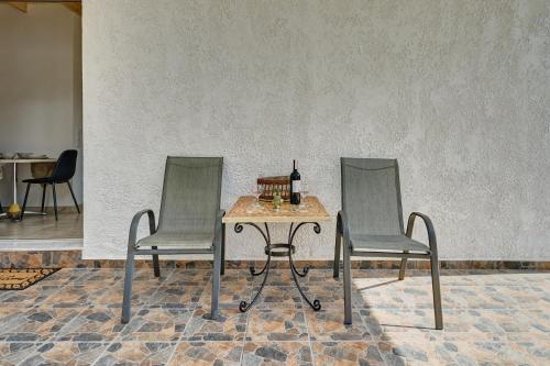 two chairs and a table with a bottle of wine at Valley View Studio Apartment Salakos in Sálakos
