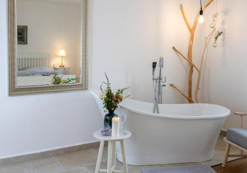 a white bath tub in a bathroom with a mirror at Apartmány Pernek in Horní Planá