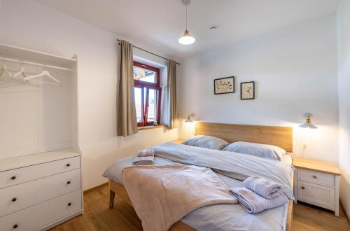 a bedroom with two beds and a dresser and a window at Apartmány Pernek in Horní Planá
