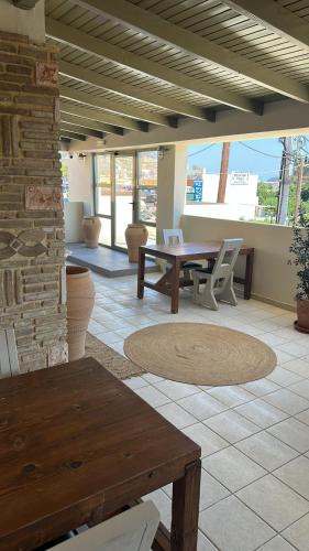 a patio with a wooden table and chairs and a table at Lodge Modern Apartments - in Kalamaki Center, by ZanteWize in Zakynthos