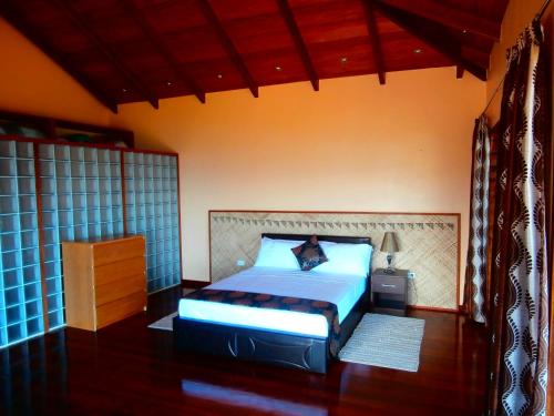 a bedroom with a bed and a dresser in it at Korovesi Sunshine Villas in Savusavu