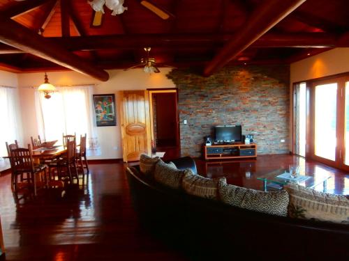 a living room with a table and chairs and a tv at Korovesi Sunshine Villas in Savusavu