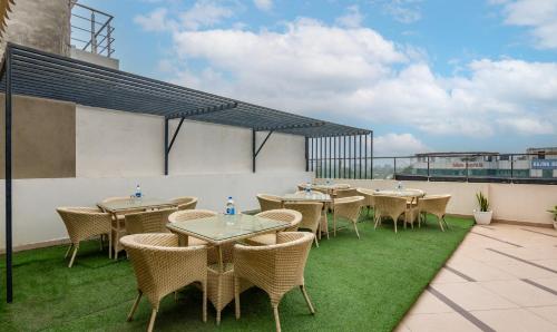 a patio with tables and chairs on a roof at Treebo JD Residency Mohali in Chandīgarh
