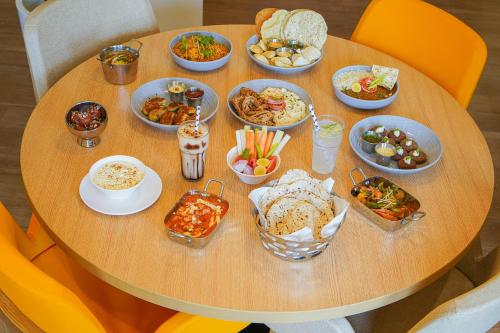 a table with many different dishes of food on it at Bloom Hotel Katra in Katra