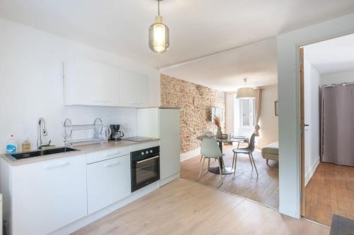 Il comprend un salon et une cuisine équipée d'appareils électroménagers blancs. dans l'établissement Cabana & Escapade Sud Mâconnaise, à Prissé