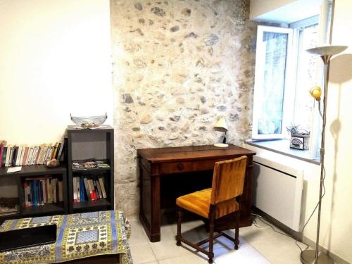 un bureau en bois avec une chaise à côté d'une fenêtre dans l'établissement Maison de village au bord de l'eau, à Saint-Bauzille-de-Putois