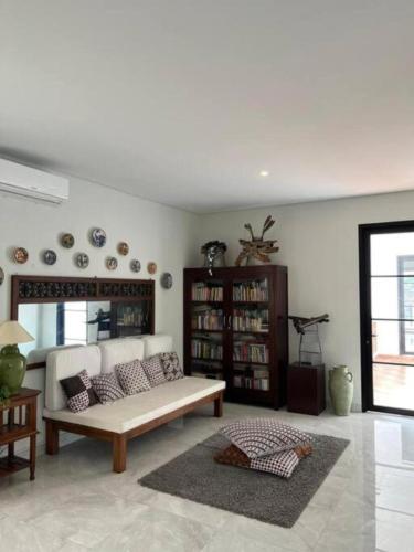 a living room with a couch and a book shelf at Aashraya Luxury Villa by Sampai in Ngemplak