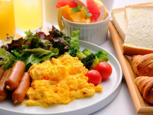un plato de comida con huevos, verduras y pan en HOTEL SUI HAMAMATSU by ABEST, en Hamamatsu