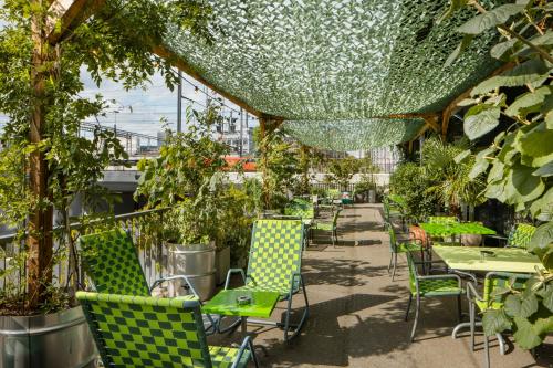 a patio with green chairs and tables and plants at 25hours Hotel Langstrasse in Zürich