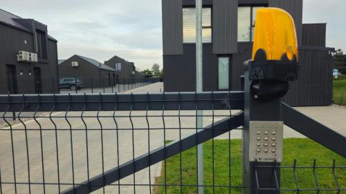 a parking meter in front of a fence at SMĖLĖTOS KOPOS - Mano jūra 3 in Kunigiškiai