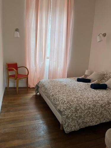a bedroom with a bed and a chair and a window at La Villa Louana 3 Appartement 60m2 ,élégance et indépendance cœur de ville in Aubusson