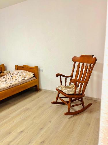 a rocking chair and a bed in a room at EFESA Apartments in Visoko