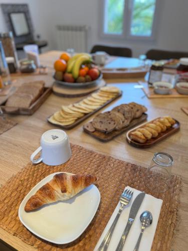 - une table en bois avec du pain et des viennoiseries dans l'établissement La Maison Du Castellet, au Castellet
