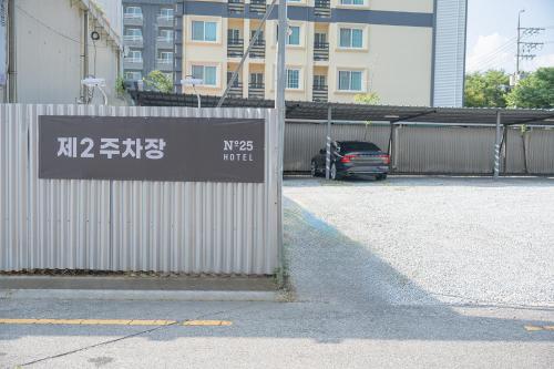 a sign on a fence next to a parking lot at No25 Hotel Jeonju Sanjeong in Jeonju