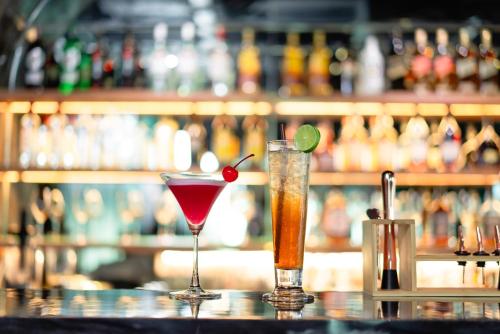 two cocktails sitting on top of a bar at Mintra Hotel in Vientiane