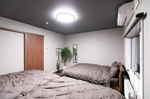 a bedroom with a bed next to a window at S9W13 LABOINN Large private house in Sapporo