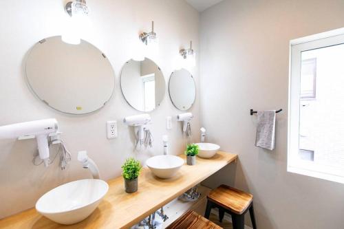 a bathroom with two sinks and two mirrors at S9W13 LABOINN Large private house in Sapporo