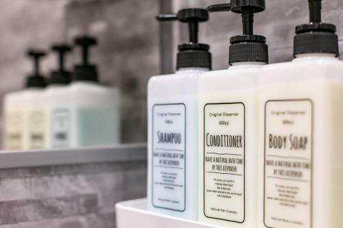 three bottles of lotion are sitting on a shelf at S9W13 LABOINN Large private house in Sapporo
