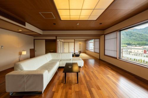 a living room with a couch and a large window at Kinugawa Hotel Mikazuki in Nikko