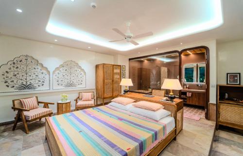 a bedroom with a bed and a desk and chairs at Artisav House-A Luxury Boutique Stay in Jaipur