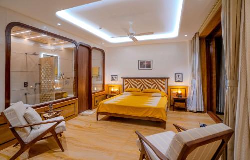 a bedroom with a yellow bed and a bathroom at Artisav House-A Luxury Boutique Stay in Jaipur