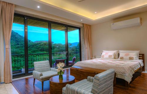 a bedroom with a bed and a large window at Artisav House-A Luxury Boutique Stay in Jaipur