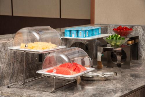 a buffet with fruit in plastic containers on a counter at True Go Hotel - Guangzhou International Conference Center Memorial Hall Subway Station in Guangzhou