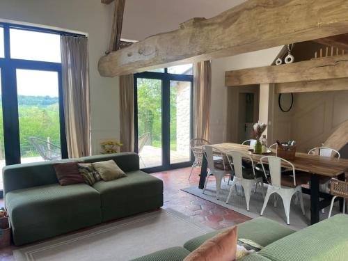 un salon avec un canapé vert et une table dans l'établissement Magnifique maison au coeur de la campagne normande, à La Chapelle-Haute-Grue