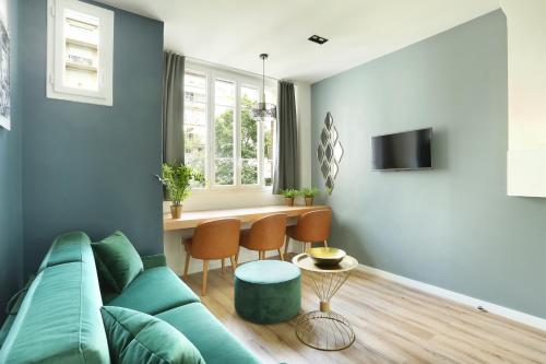 un salon avec un canapé vert et une table dans l'établissement YAYS Paris Zola by Numa, à Paris