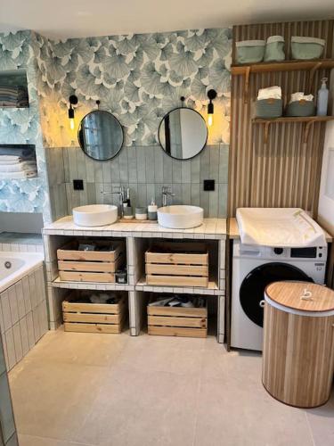 une salle de bain avec deux lavabos et une machine à laver dans l'établissement Magnifique maison au coeur de la campagne normande, à La Chapelle-Haute-Grue