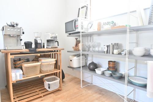 a kitchen with shelves filled with lots of items at insidey 海から歩いて10分 walk from the sea Tatadobeach Iritabeach 10min in Shimoda
