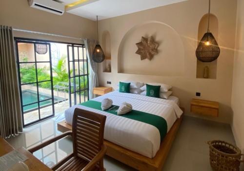 a bedroom with a large bed and a large window at Sampai Villa Sahara in Yogyakarta