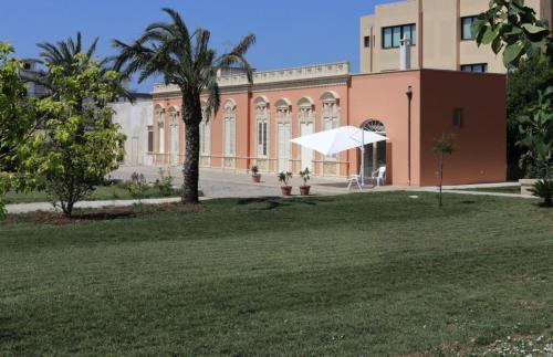 a white umbrella in front of a building at Dimora Caputo - Perla nel verde in Nardò