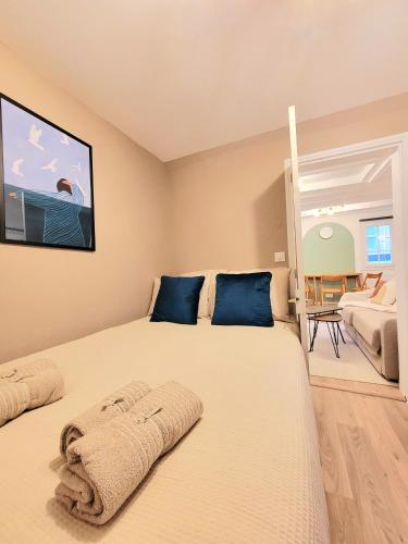 a bedroom with a large white bed with blue pillows at Charmante Cocotte in Barentin