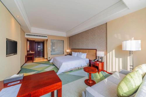 a hotel room with a bed and a couch at Holiday Inn Foshan Nanhai Central by IHG in Foshan