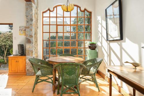 a dining room with a table and chairs and a window at Idyllic Villa - Rooftop Deck - Mountain Views in Cape Town