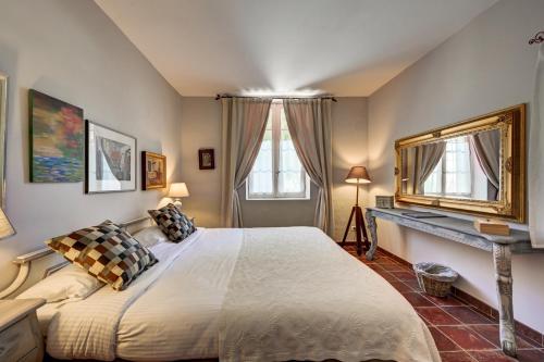 a bedroom with a large bed and a mirror at Mas des Comtes de Provence in Tarascon
