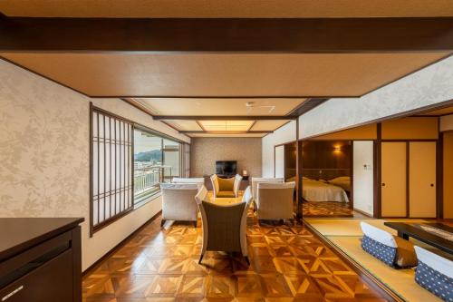 a room with a table and chairs and a bed at Kinugawa Hotel Mikazuki in Nikko