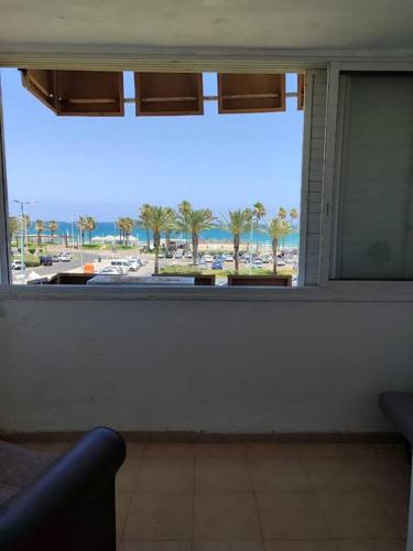 a window in a room with a view of a beach at Home with a balcony by the sea 60-5 in Qiryat H̱ayyim