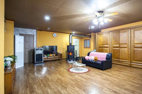 a living room with a couch and a tv at hongcheon river view sonamu pension in Hongcheon