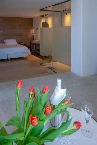 a vase with red flowers in a room at Hotel Adonis in Mýkonos City